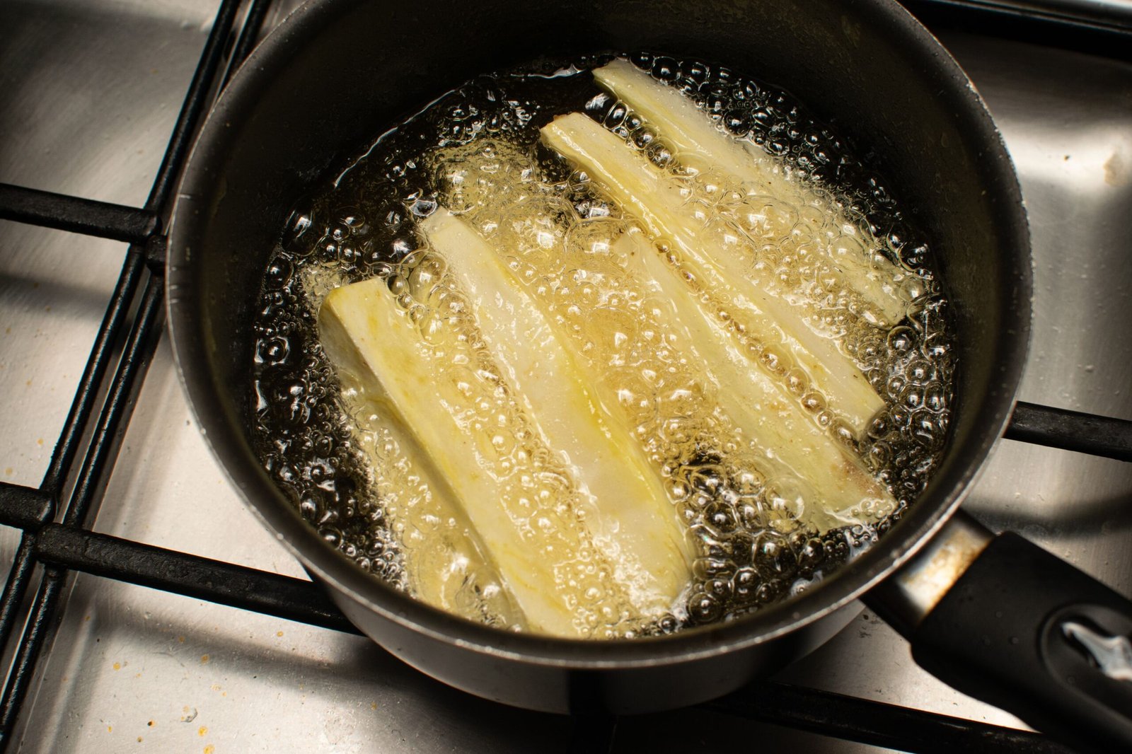 Cassava sticks frying in oil (macaxeira frita)