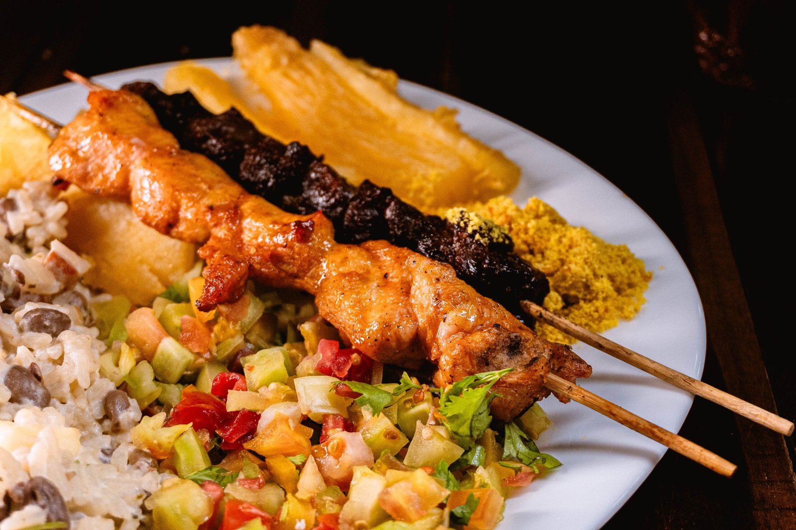 Brazilian barbecue plate with skewers, farofa, cassava and vinagrete