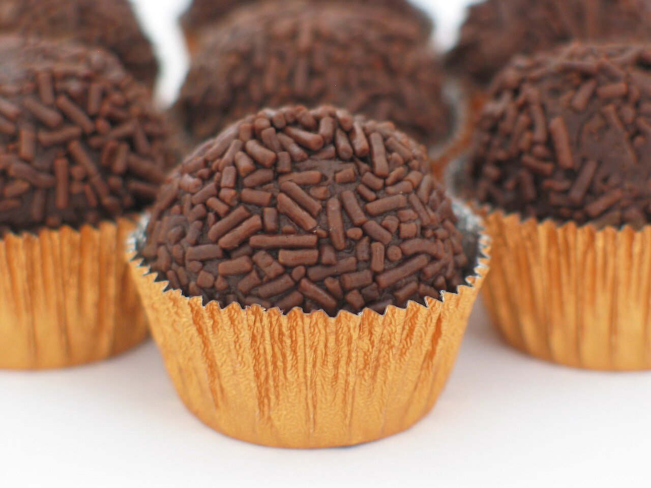 Classic Brazilian brigadeiros: chocolate fudge balls rolled in chocolate sprinkles, in gold paper cups