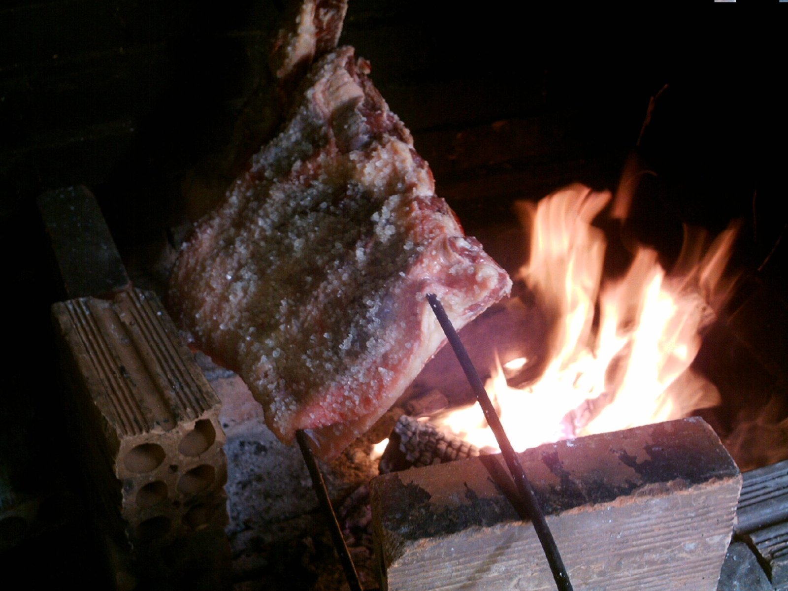 Beef ribs cooking over an open fire