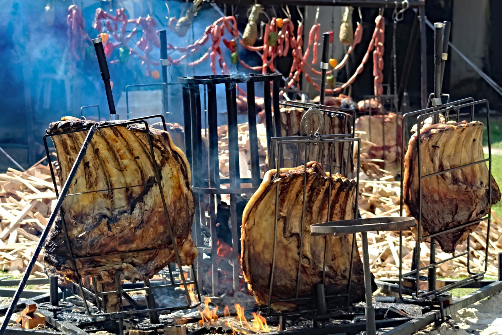 Beef ribs in a circle of metal frames around a central ground fire (fogo de chao)