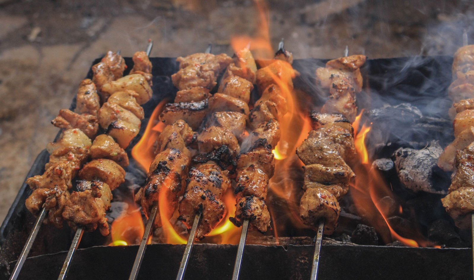Chicken and meat on skewers over the fire
