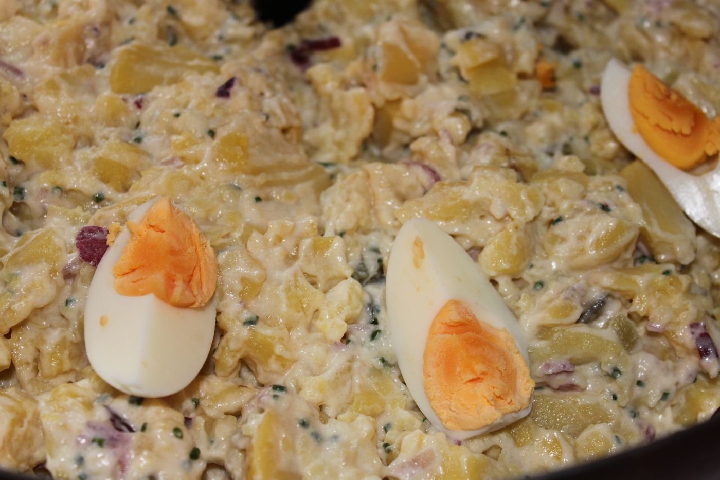 Mayonnaise potato salad with herbs and hard-boiled egg wedges