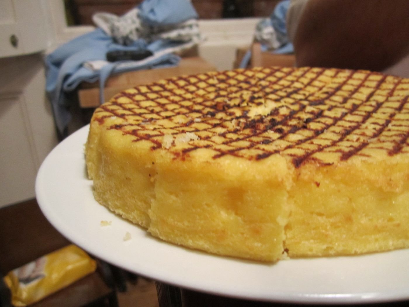 Thick round of grilled polenta with grate marks on a white plate